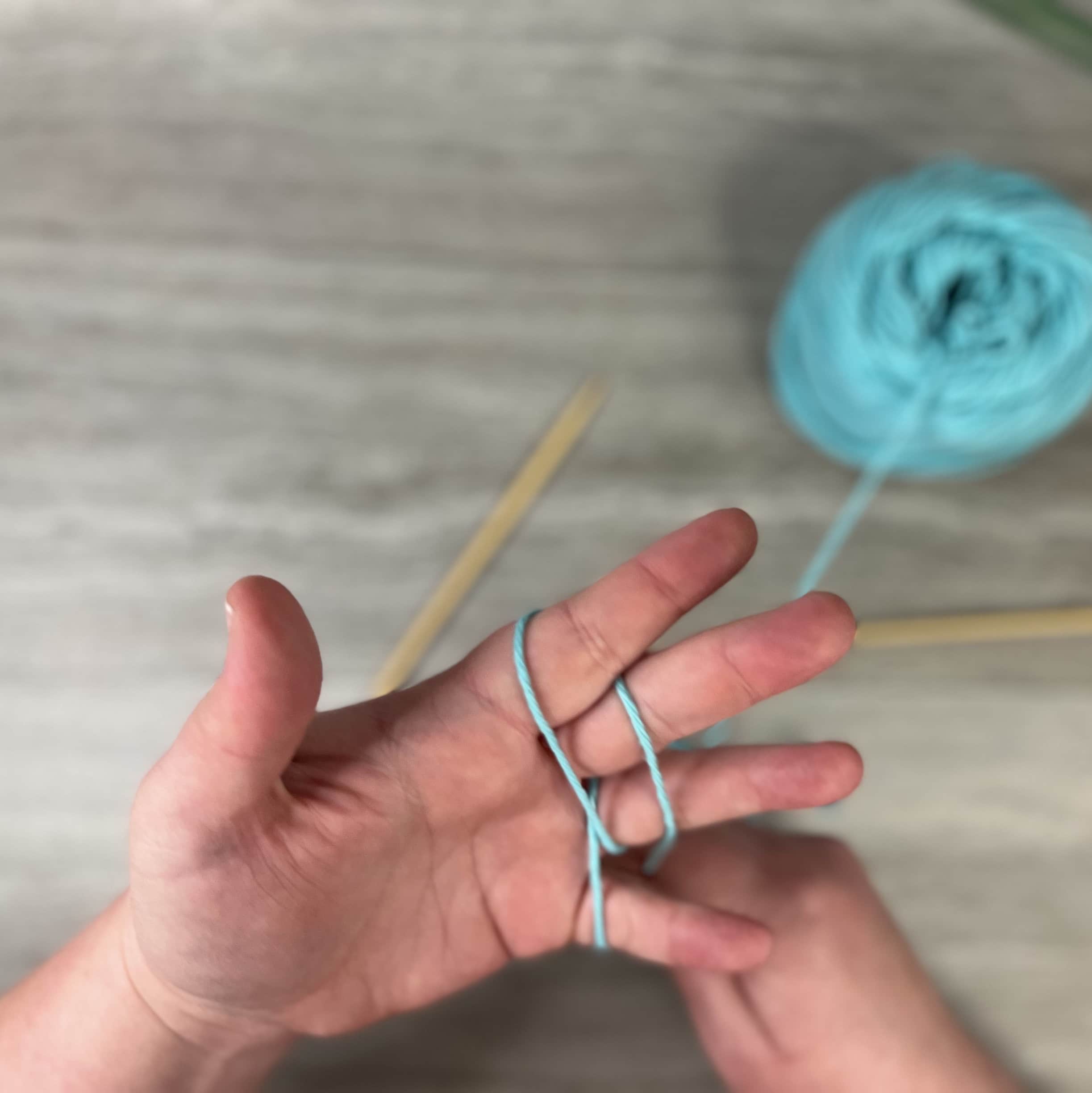 wrapping your fingers in yarn for tension taming is not a great skill for a beginner knitter to learn